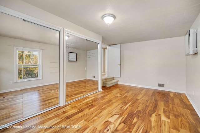 unfurnished bedroom featuring a textured ceiling and light hardwood / wood-style flooring