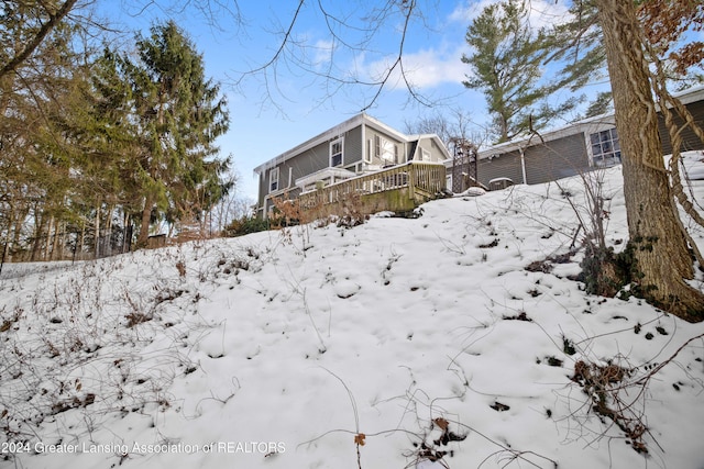 yard layered in snow featuring a deck