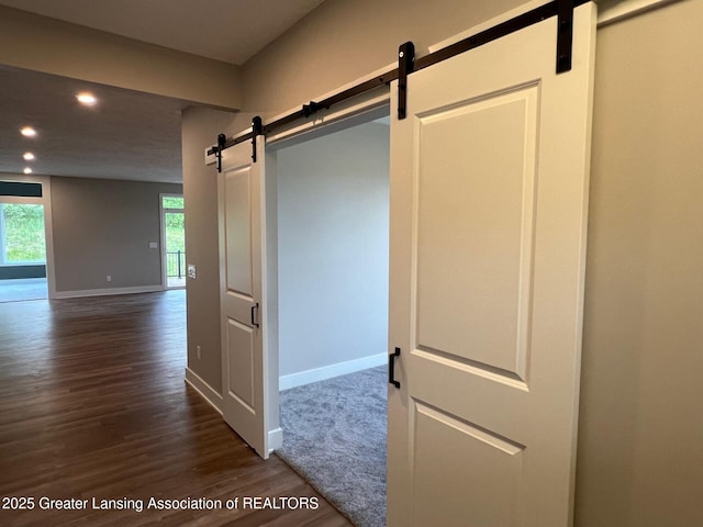 6097 Southridge Rd, East Lansing, MI 48823 - hallway featuring a barn door, recessed lighting, dark wood-style flooring, baseboards, and healthy amount of natural light