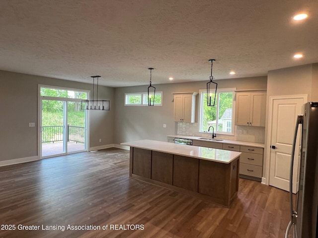 6097 Southridge Rd, East Lansing, MI 48823 - kitchen featuring a sink, stainless steel appliances, baseboards, dark wood-style floors, and a textured ceiling