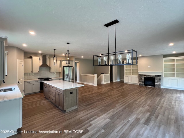 6097 Southridge Rd, East Lansing, MI 48823 - kitchen featuring appliances with stainless steel finishes, wall chimney exhaust hood, open floor plan, light countertops, and recessed lighting