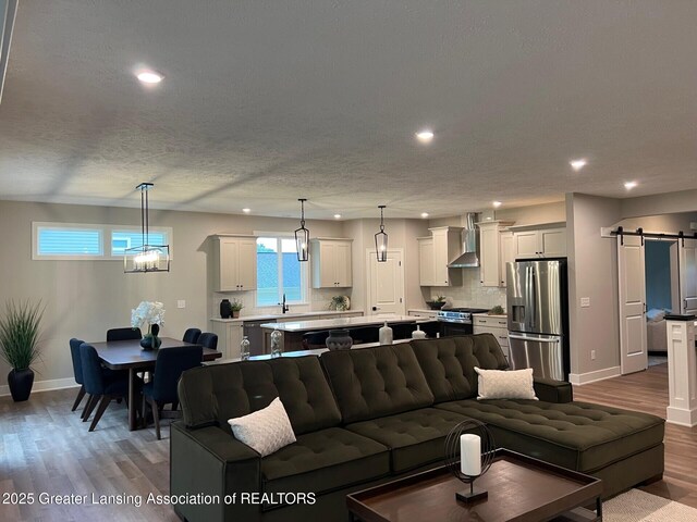 6097 Southridge Rd, East Lansing, MI 48823 - living room featuring recessed lighting, a barn door, and wood finished floors