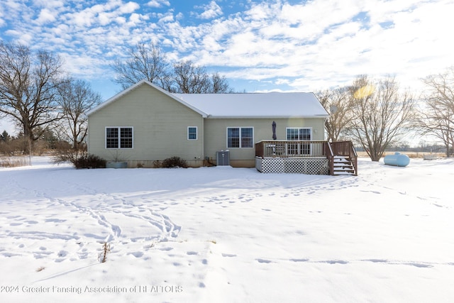 snow covered property with a deck and central AC