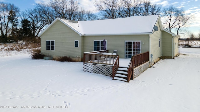 snow covered house featuring a deck