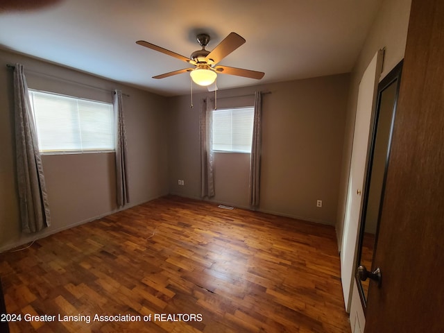 spare room with dark wood-type flooring and ceiling fan