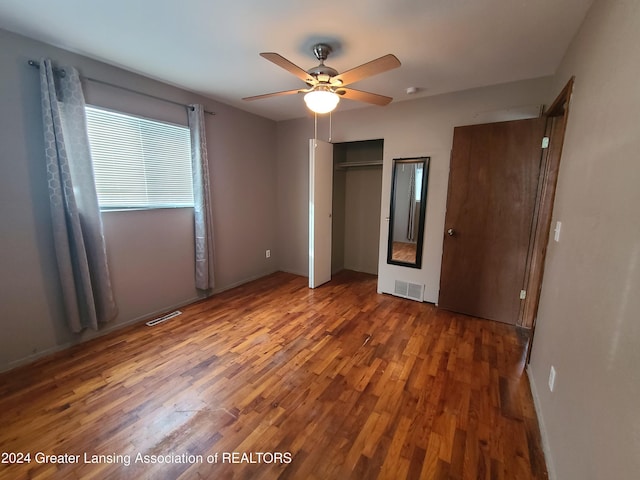 unfurnished bedroom with ceiling fan and dark hardwood / wood-style flooring