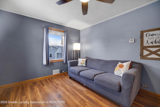 living room with hardwood / wood-style flooring, a textured ceiling, and ceiling fan