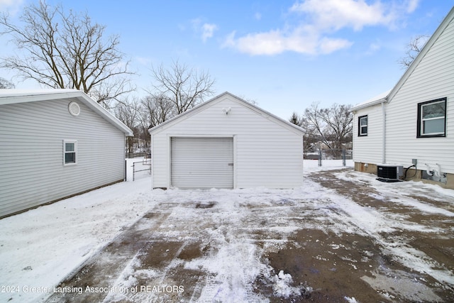 snow covered garage with central AC unit