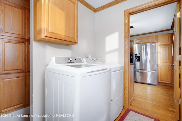 washroom with ornamental molding, light hardwood / wood-style floors, cabinets, and independent washer and dryer