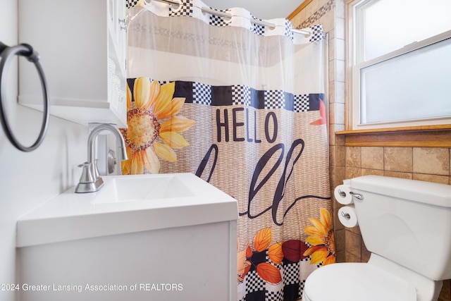 bathroom with sink, toilet, tile walls, and a shower with shower curtain