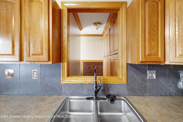 kitchen with decorative backsplash, sink, and ornamental molding