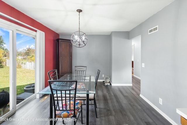 dining area with an inviting chandelier and dark wood-type flooring