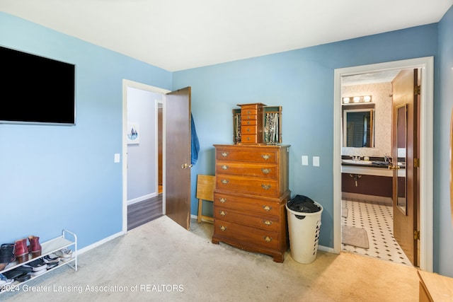 bedroom featuring ensuite bathroom and carpet floors