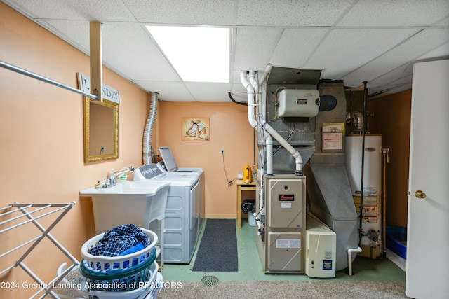 clothes washing area with washer and clothes dryer and water heater