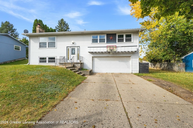 bi-level home featuring a garage and a front lawn