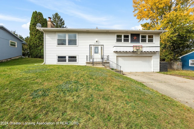 raised ranch with a garage and a front yard