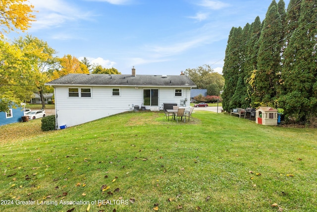 rear view of house featuring a yard