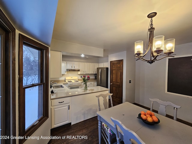 dining space featuring sink, a notable chandelier, and dark wood-type flooring