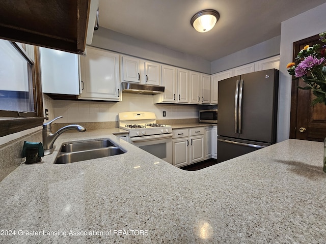 kitchen featuring sink, light stone counters, white cabinetry, and stainless steel appliances