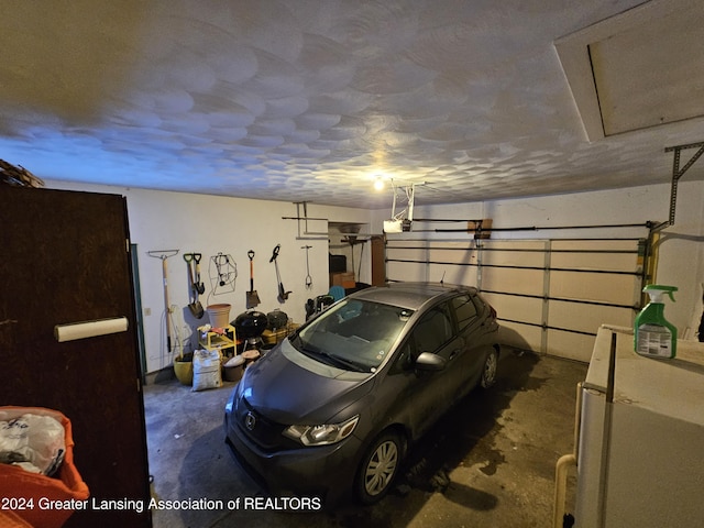 garage featuring white refrigerator and a garage door opener