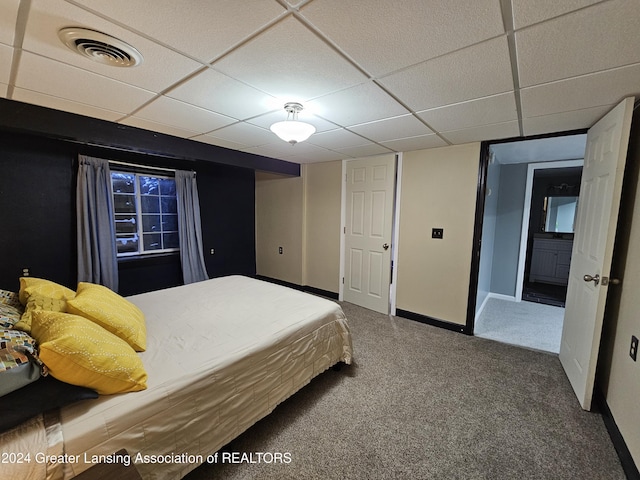 bedroom featuring carpet floors and a drop ceiling