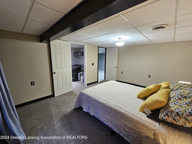 carpeted bedroom featuring a drop ceiling