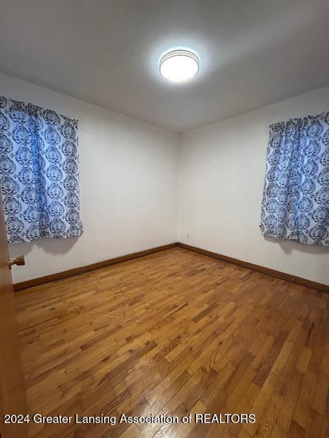 unfurnished room featuring baseboards and wood finished floors