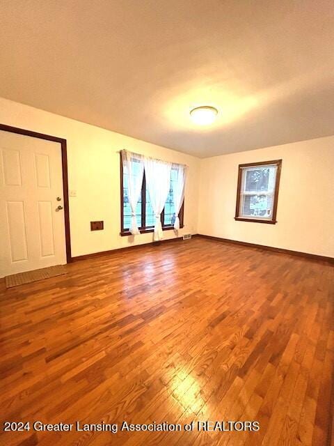 unfurnished room with baseboards and wood finished floors