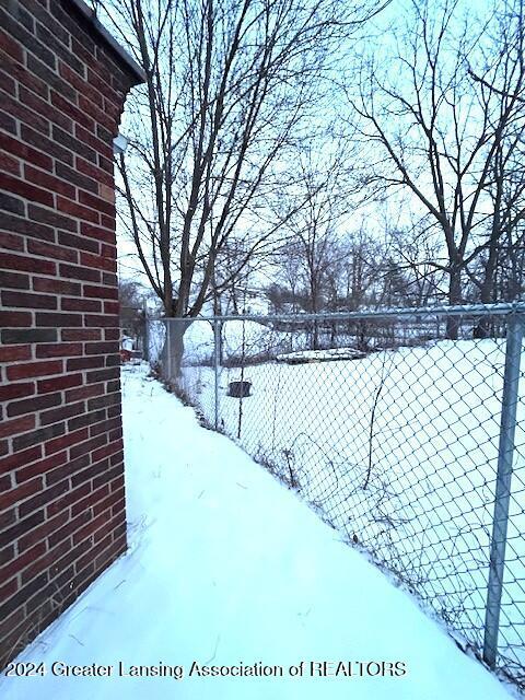 yard layered in snow featuring fence