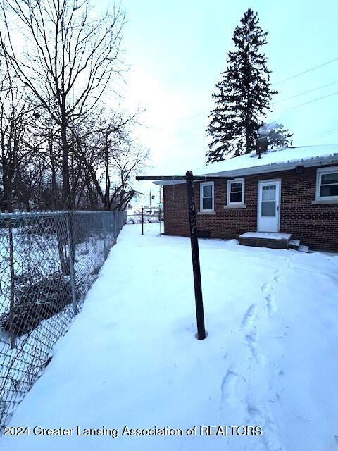 yard covered in snow with fence