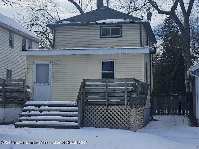 view of snow covered back of property