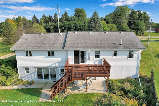 back of property featuring a patio area, a wooden deck, and a yard