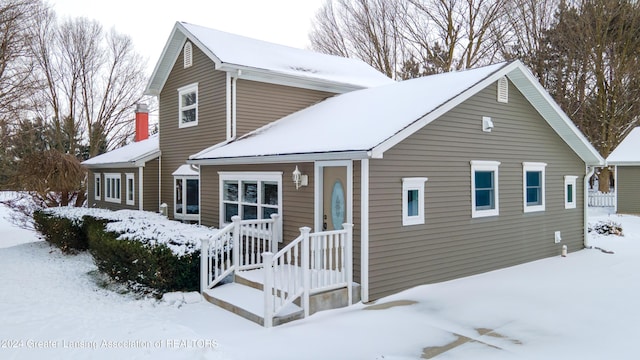 view of snow covered rear of property