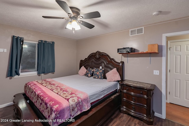 bedroom featuring ceiling fan, dark wood-type flooring, and a textured ceiling