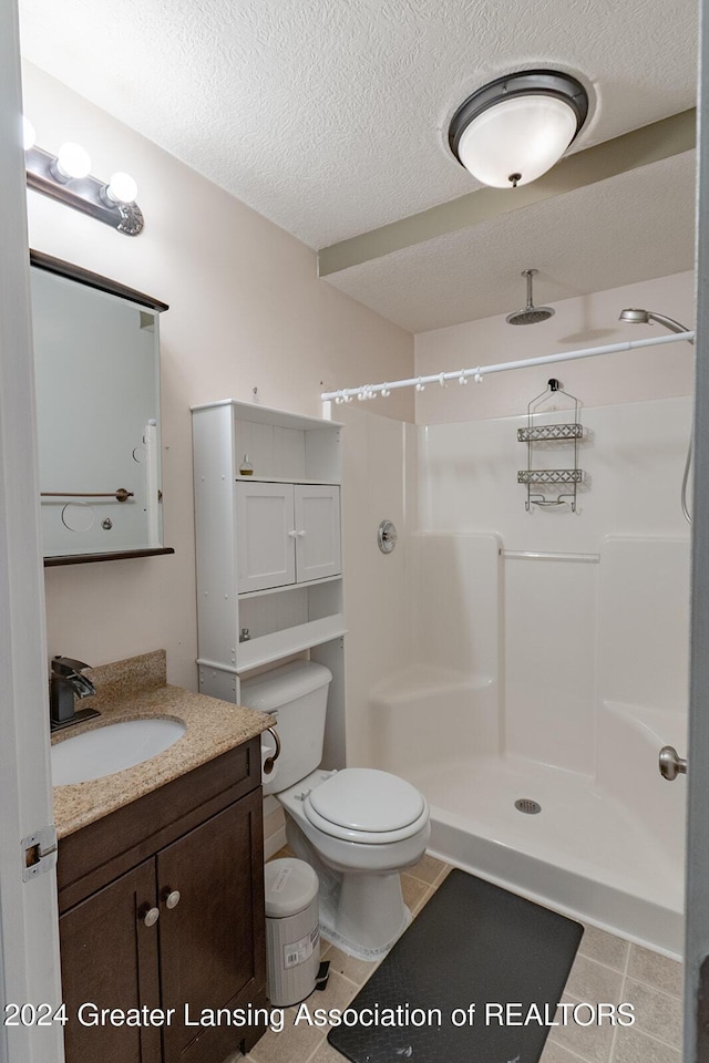 bathroom with toilet, tile patterned flooring, walk in shower, a textured ceiling, and vanity