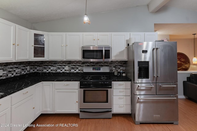 kitchen with white cabinets, appliances with stainless steel finishes, decorative light fixtures, tasteful backsplash, and vaulted ceiling with beams