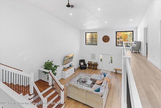 living room featuring high vaulted ceiling and light hardwood / wood-style flooring