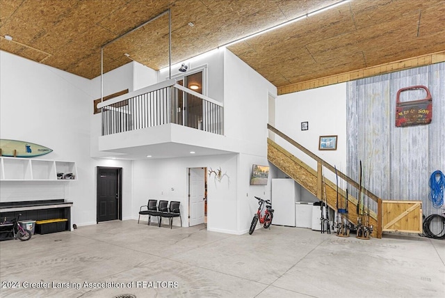 living room featuring concrete floors and a towering ceiling