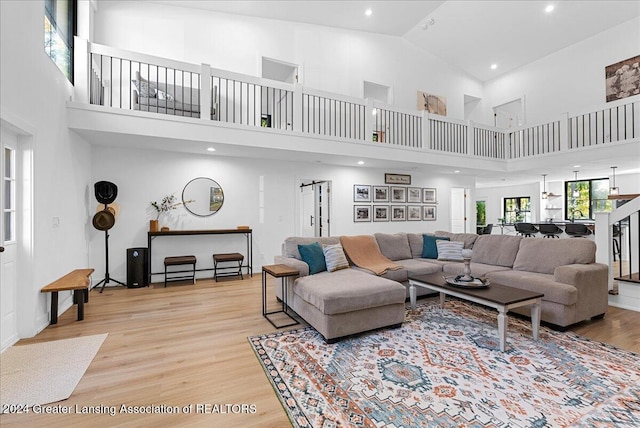 living room featuring a towering ceiling and light wood-type flooring