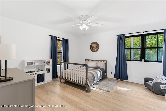 bedroom with ceiling fan and light hardwood / wood-style floors