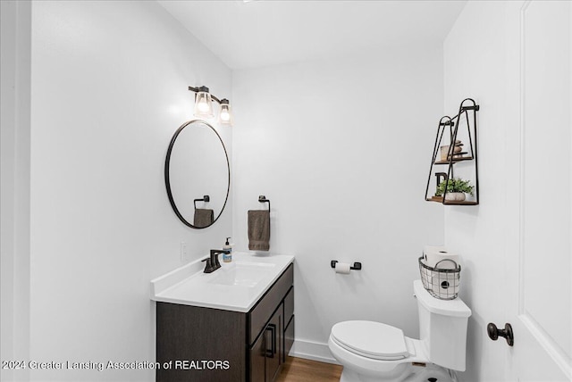 bathroom featuring wood-type flooring, toilet, and vanity