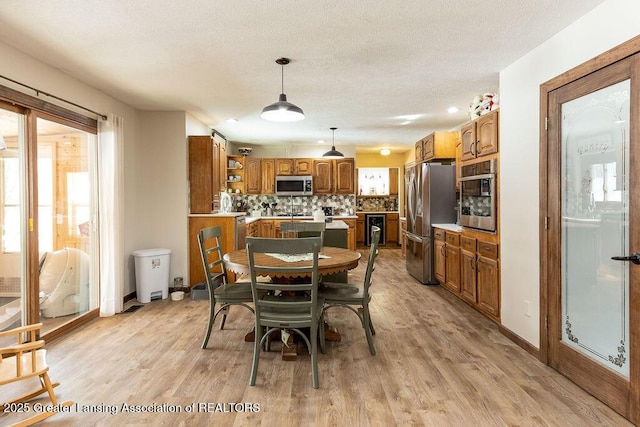 dining room featuring light hardwood / wood-style flooring and a textured ceiling