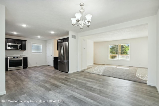 kitchen featuring hardwood / wood-style flooring, appliances with stainless steel finishes, and a chandelier