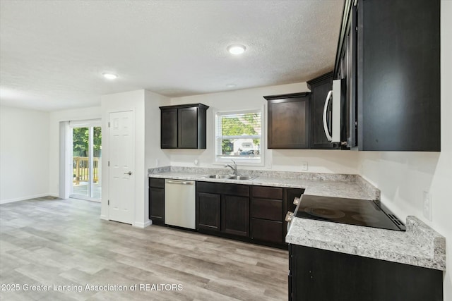 kitchen with stainless steel appliances, plenty of natural light, sink, and light wood-type flooring