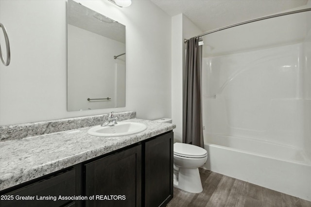 full bathroom with vanity, hardwood / wood-style flooring, shower / bath combo, and toilet