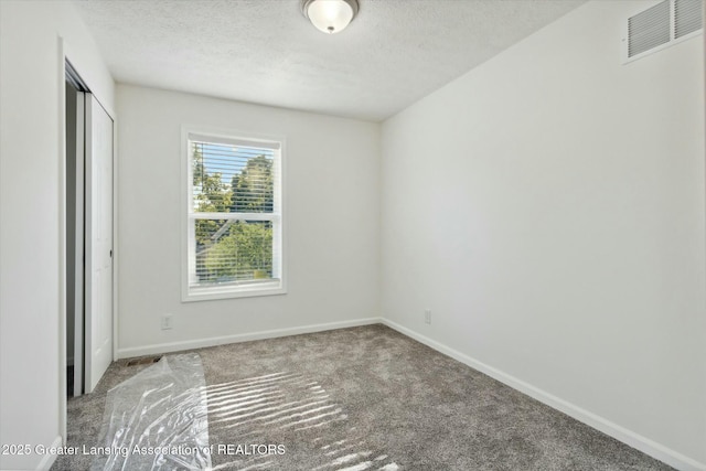 unfurnished bedroom featuring carpet floors, a textured ceiling, and a closet