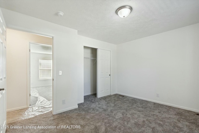 unfurnished bedroom featuring a closet, a textured ceiling, and carpet flooring