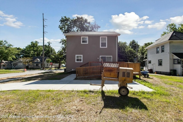 back of property featuring a yard, a patio area, and a deck