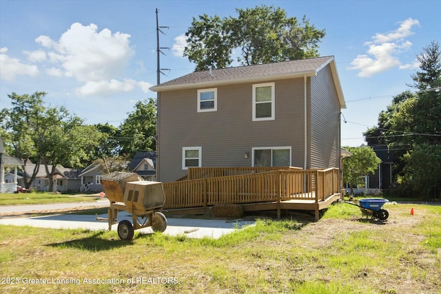 rear view of house with a wooden deck and a yard