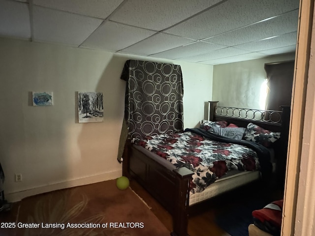 bedroom featuring baseboards and a drop ceiling